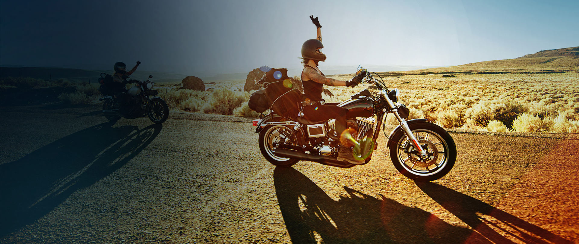 Two people on motorbikes on the road.